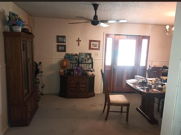 carpeted dining area featuring a ceiling fan and a textured ceiling