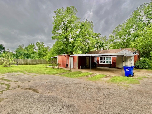 view of outdoor structure featuring fence and driveway
