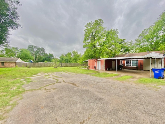 exterior space with fence and a carport