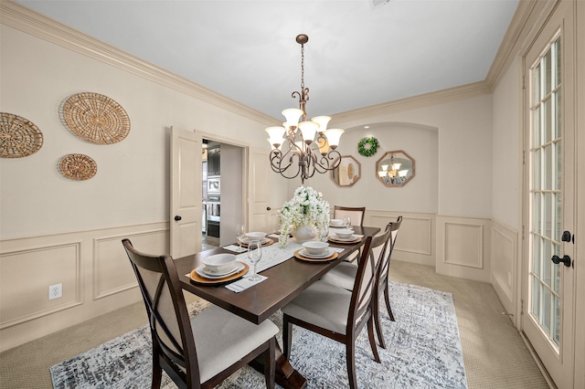 dining room with wainscoting, light carpet, and a decorative wall