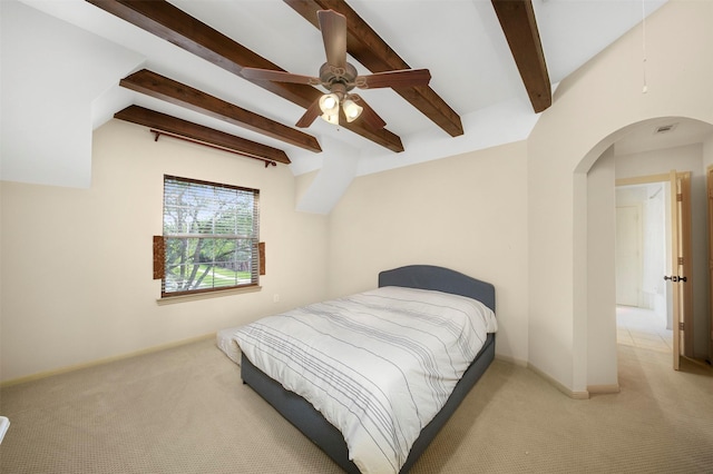 bedroom with arched walkways, carpet, and beam ceiling