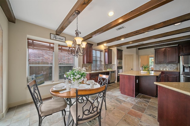 dining area featuring a notable chandelier, beam ceiling, baseboards, visible vents, and stone tile flooring