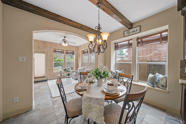 dining room with arched walkways, baseboards, beam ceiling, and ceiling fan with notable chandelier