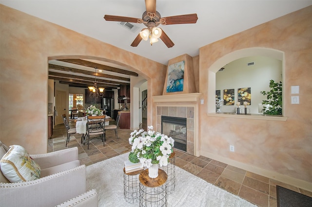 living area featuring visible vents, a ceiling fan, baseboards, and a tile fireplace