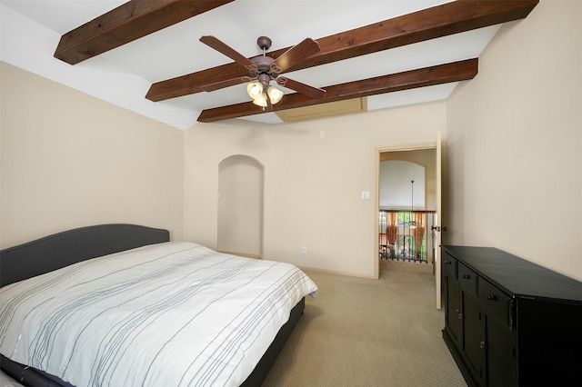 bedroom featuring a ceiling fan, light colored carpet, and beam ceiling