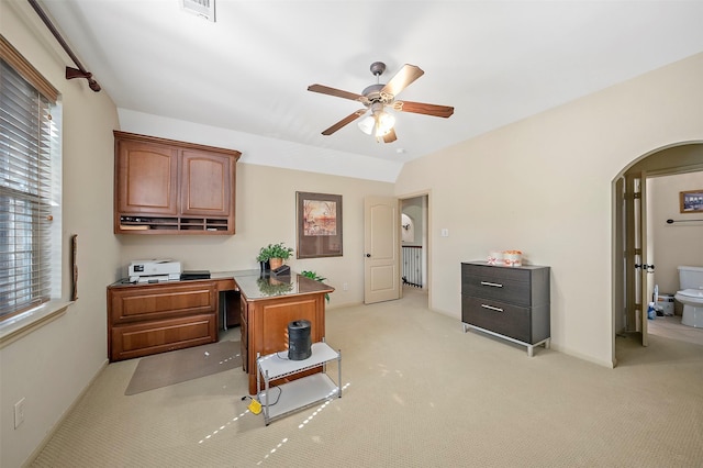 office area featuring ceiling fan, light colored carpet, arched walkways, baseboards, and visible vents
