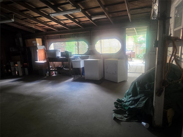 misc room with separate washer and dryer, concrete flooring, and a garage