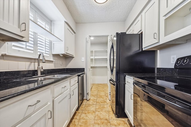 kitchen featuring a textured ceiling, black electric range, tasteful backsplash, dishwasher, and a sink