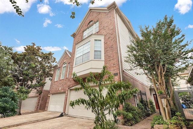 view of front facade featuring concrete driveway, brick siding, and an attached garage