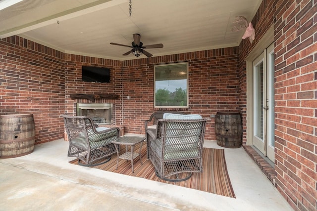 view of patio with a ceiling fan and an outdoor brick fireplace