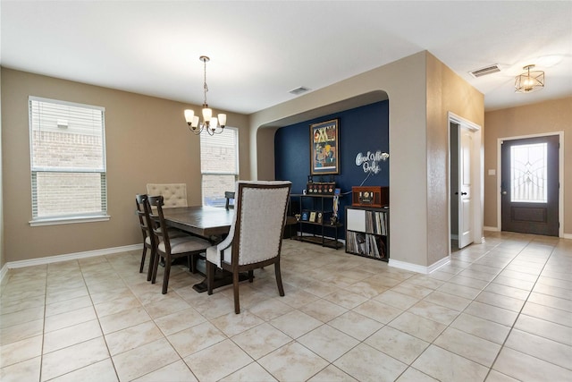 dining area with an inviting chandelier, light tile patterned floors, and a healthy amount of sunlight