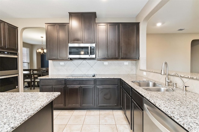 kitchen with a sink, arched walkways, backsplash, and stainless steel appliances