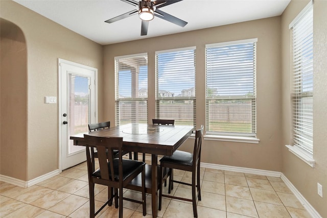 dining space featuring baseboards, ceiling fan, and light tile patterned flooring