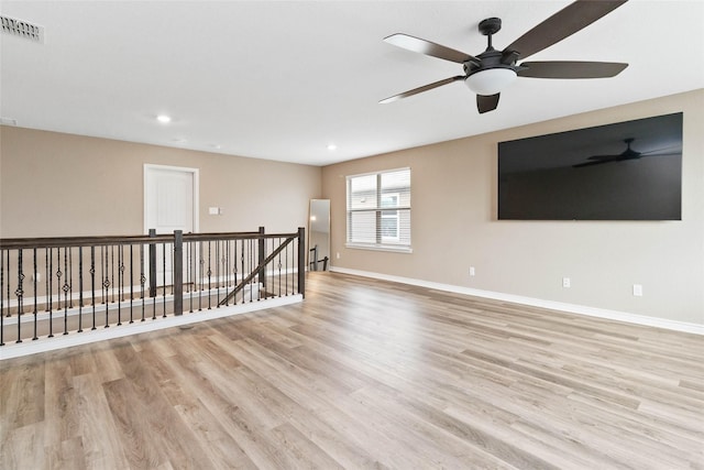 unfurnished room with visible vents, light wood finished floors, ceiling fan, and baseboards
