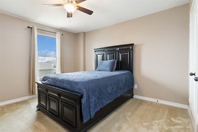 bedroom with a ceiling fan, baseboards, and light carpet