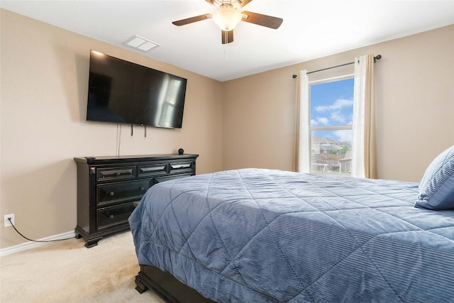 bedroom featuring a ceiling fan, baseboards, visible vents, and light carpet