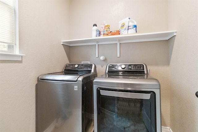clothes washing area featuring separate washer and dryer and laundry area