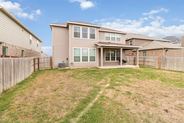 rear view of house with a yard, a fenced backyard, and a patio area
