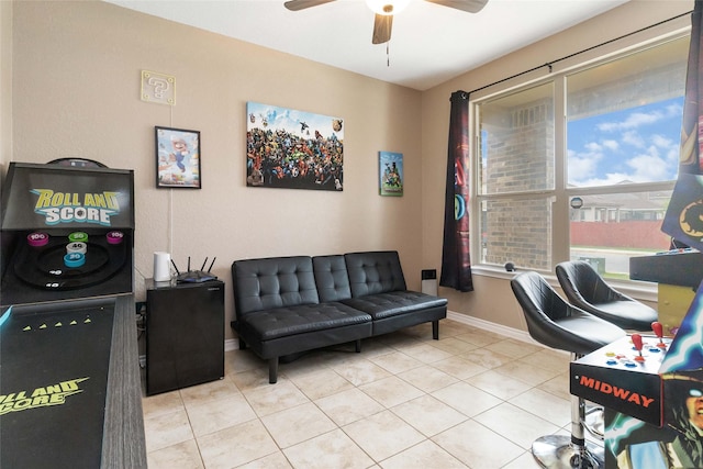 tiled office space featuring ceiling fan and baseboards