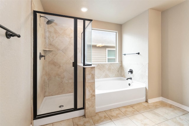full bathroom featuring a garden tub, tile patterned floors, and a shower stall