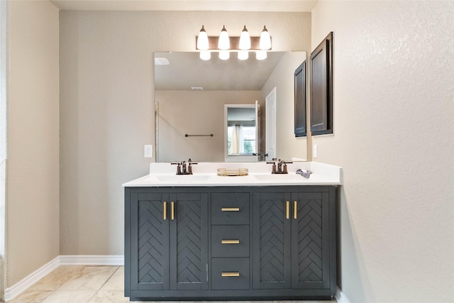 full bathroom featuring double vanity, a sink, and baseboards