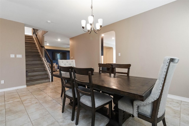 dining space featuring arched walkways, light tile patterned floors, baseboards, an inviting chandelier, and stairs