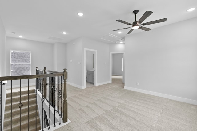 spare room featuring a ceiling fan, attic access, light colored carpet, baseboards, and recessed lighting