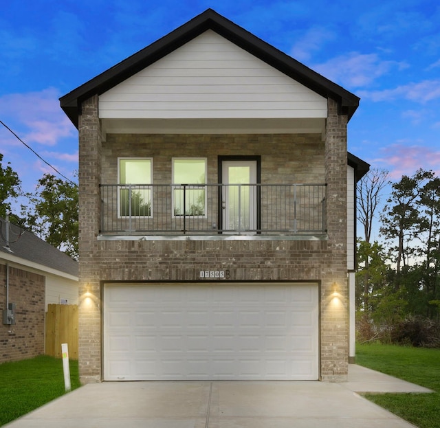 view of front of home featuring brick siding, driveway, a balcony, and a garage
