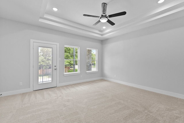 carpeted empty room with baseboards, a tray ceiling, and recessed lighting