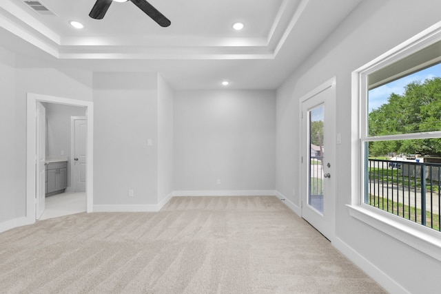 interior space with multiple windows, visible vents, access to exterior, and a raised ceiling