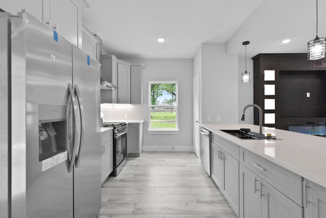 kitchen featuring a sink, recessed lighting, stainless steel appliances, and light wood-type flooring