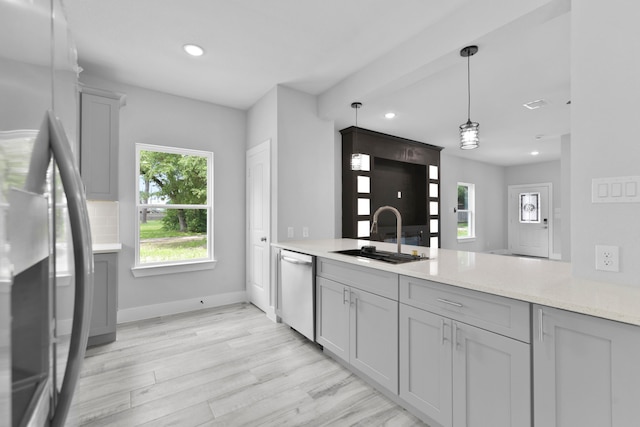 kitchen with recessed lighting, a sink, light wood finished floors, appliances with stainless steel finishes, and gray cabinetry