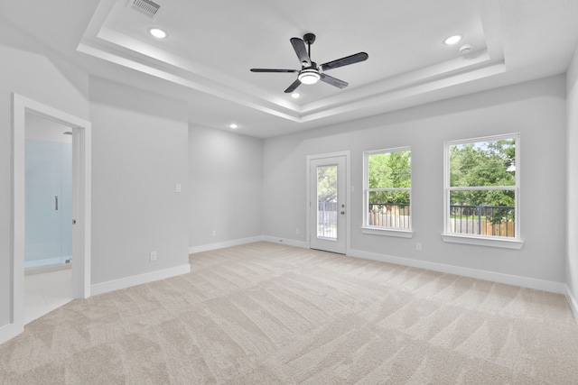 empty room featuring ceiling fan, carpet, recessed lighting, a tray ceiling, and visible vents