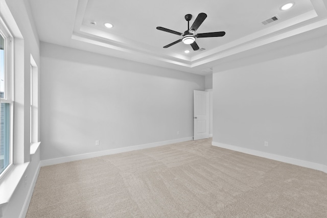 carpeted spare room featuring a ceiling fan, a tray ceiling, recessed lighting, and visible vents