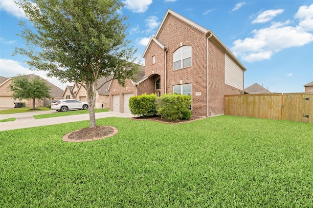 view of front of property with concrete driveway, brick siding, fence, and a front yard