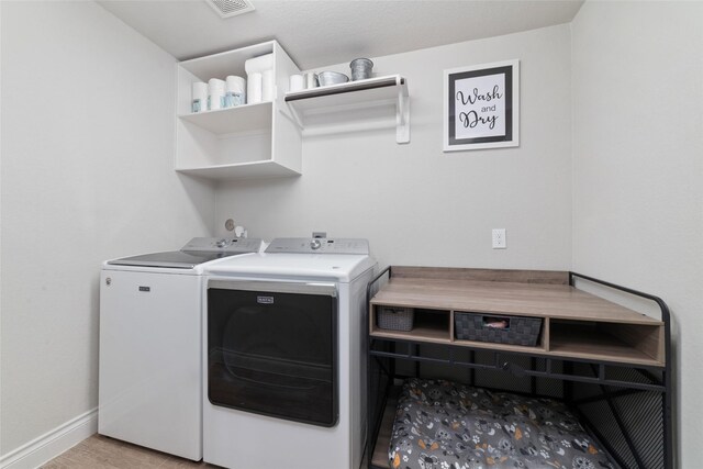 washroom featuring baseboards, laundry area, washing machine and dryer, and visible vents