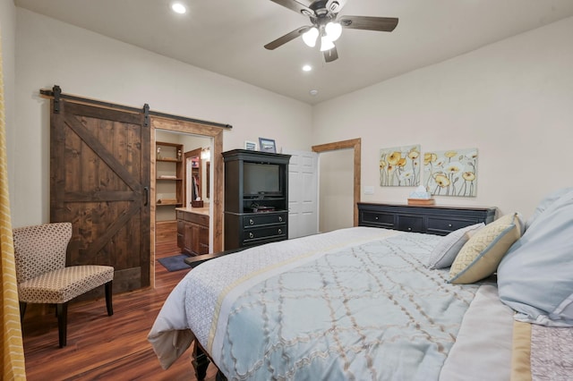 bedroom featuring dark wood-type flooring, a barn door, a ceiling fan, and recessed lighting