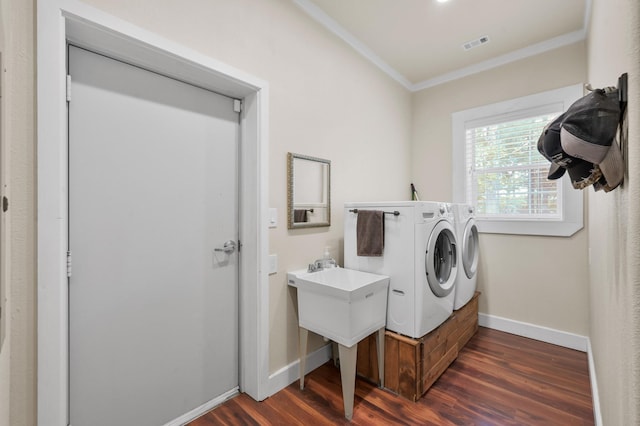 laundry area with laundry area, crown molding, baseboards, washing machine and clothes dryer, and dark wood finished floors