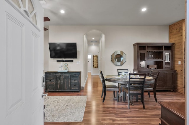 dining space featuring visible vents, arched walkways, wood finished floors, and recessed lighting