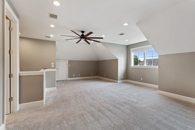 additional living space featuring a ceiling fan, visible vents, baseboards, lofted ceiling, and light carpet