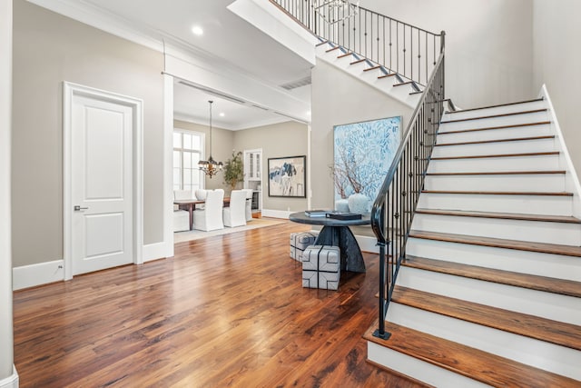 stairway with visible vents, ornamental molding, wood finished floors, baseboards, and recessed lighting