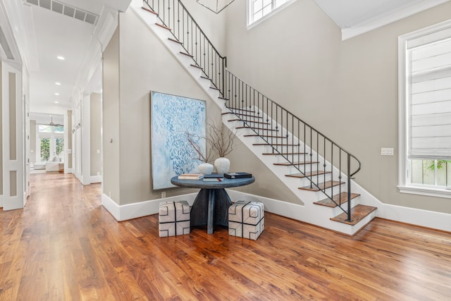 stairway with baseboards, visible vents, and wood finished floors