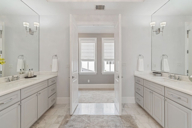 full bathroom with a sink, two vanities, and visible vents