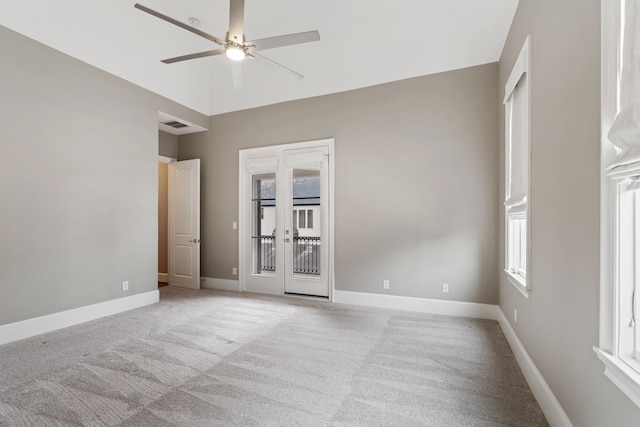 spare room with a ceiling fan, baseboards, light colored carpet, and visible vents