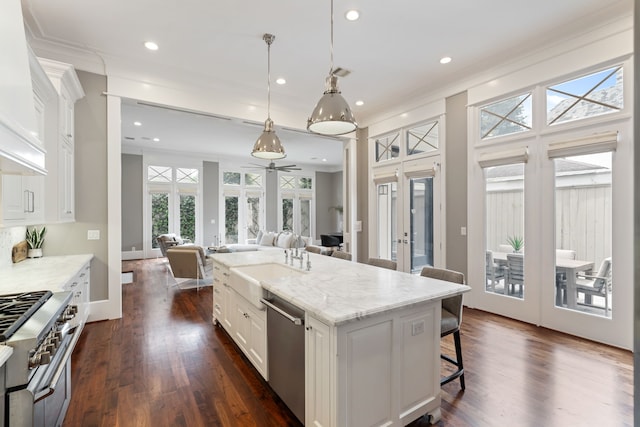 kitchen featuring white cabinetry, open floor plan, appliances with stainless steel finishes, and a kitchen breakfast bar