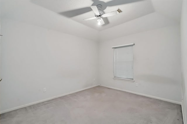 empty room with carpet floors, a ceiling fan, and baseboards