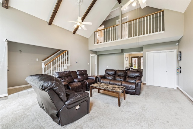 carpeted living area featuring stairs, ceiling fan, beam ceiling, and high vaulted ceiling