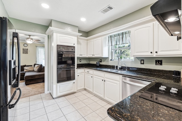 kitchen featuring white cabinets, a sink, ventilation hood, visible vents, and black appliances
