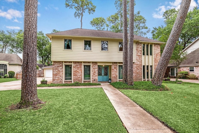 colonial inspired home with brick siding, french doors, and a front yard