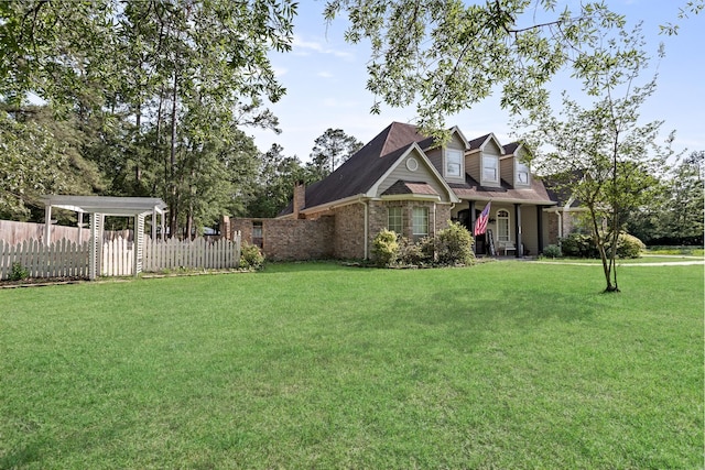 view of front of property featuring brick siding, fence, and a front yard